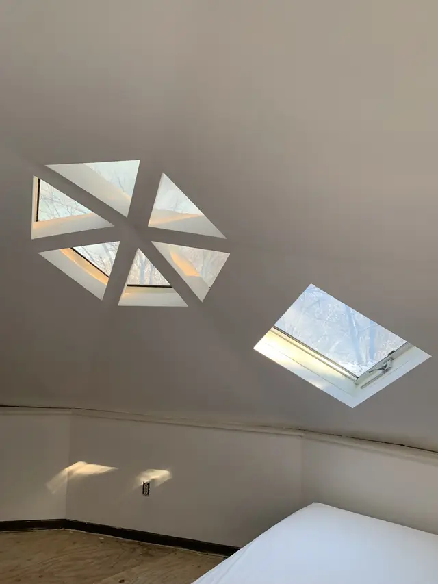 Inside a geodesic dome: smooth white faceted walls and ceiling with hexagonal skylights.