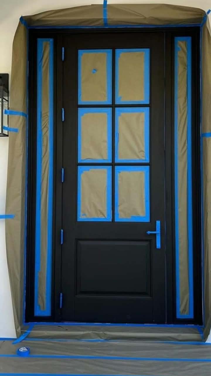 Front entry door prepped and taped for a fresh coat. — door painting, exterior door refinishing, painting prep
