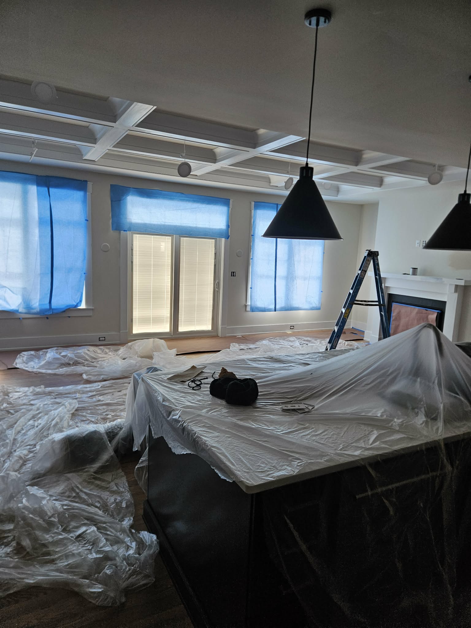 Great room prepped for painting with furniture and fixtures protected - interior painting prep.