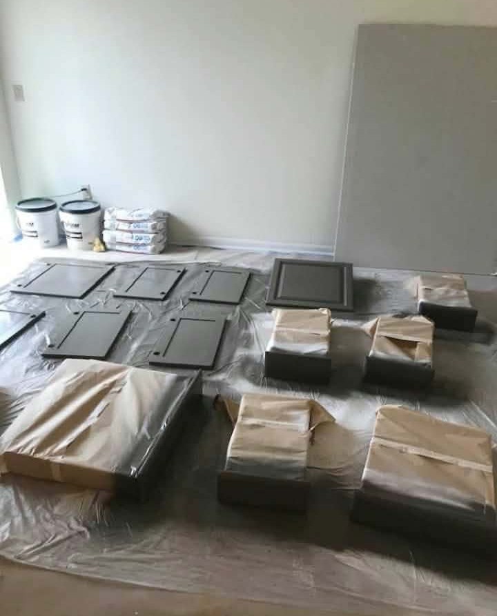 In Progress — Cabinet Door Painting — kitchen cabinet painting, cabinet refinishing, cabinet door repaint, cabinet spray painting, interior painting, dark gray cabinets, drop cloth prep, paint buckets, cabinet drawer fronts, home renovation, cabinet makeover, before and after