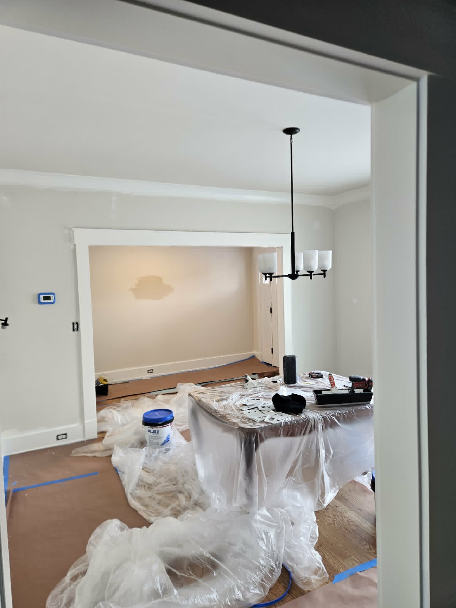 Bright dining room with smooth-finished walls and detailed white trim after a seamless drywall patch and repair — drywall and interior painting.