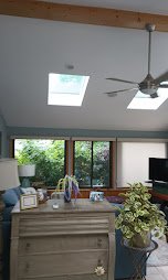 Vaulted sunroom ceiling with skylights painted bright white - interior painting.